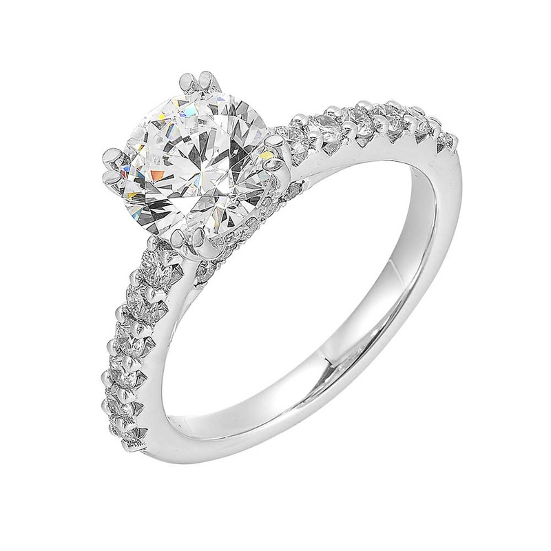 This ring boasts a classic round solitaire diamond set in dual prongs,  symbolizing timeless love. A delicate single row diamond shank makes it even more special.