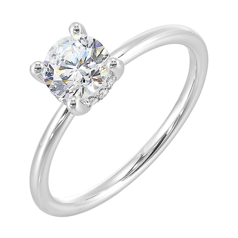 The dazzling solitare diamond take center stage. The petite band adds to the sleek,  classic look.