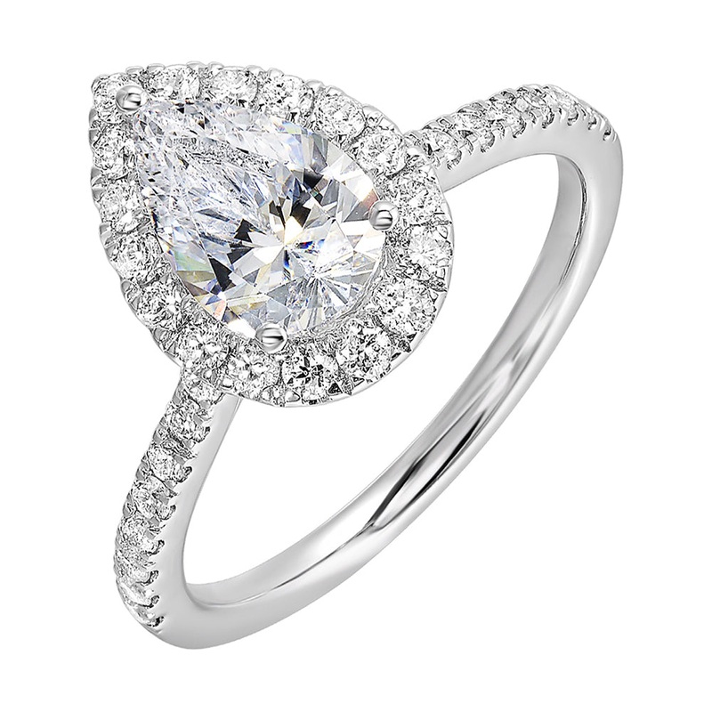 The pear cut solitare shines in this elegant ring,  embraced by a delicate halo. The diamond shank adds a touch of sparkle,  showcasing the beauty of the pear and halo at its finest.